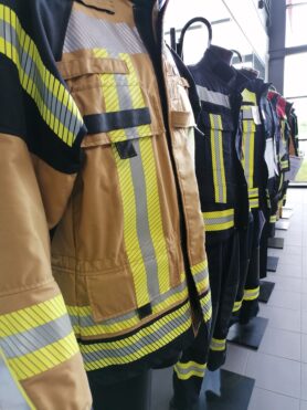 Ausstellung von Feuerwehrjacken im Verkaufsraum zur Anprobe verschiedener Marken von persönlicher Schutzausrüstung